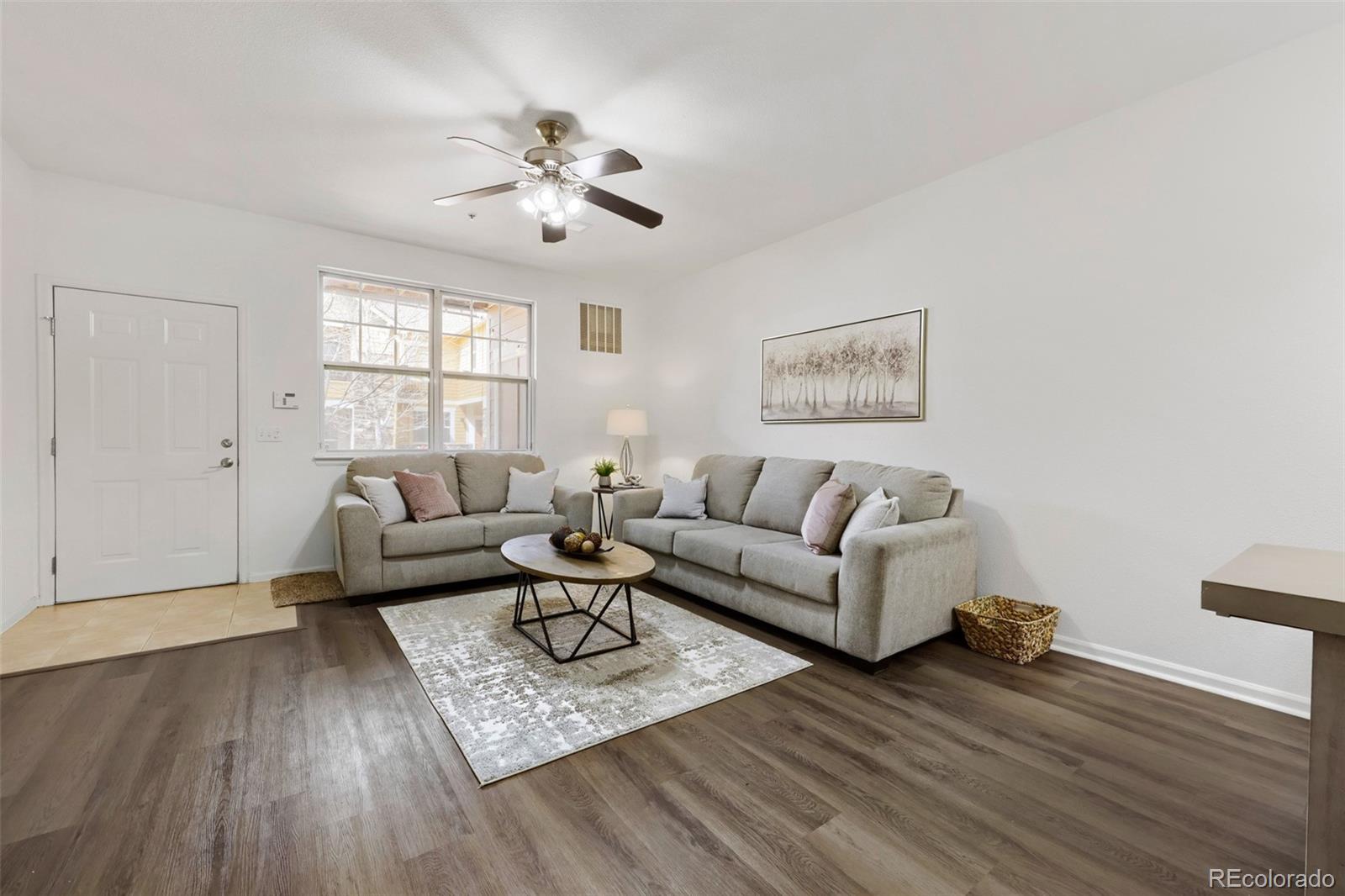 7130 Simms Street, Unit 107 Arvada, CO 80004 - Photo 5 of 29 a living room with furniture and wooden floor