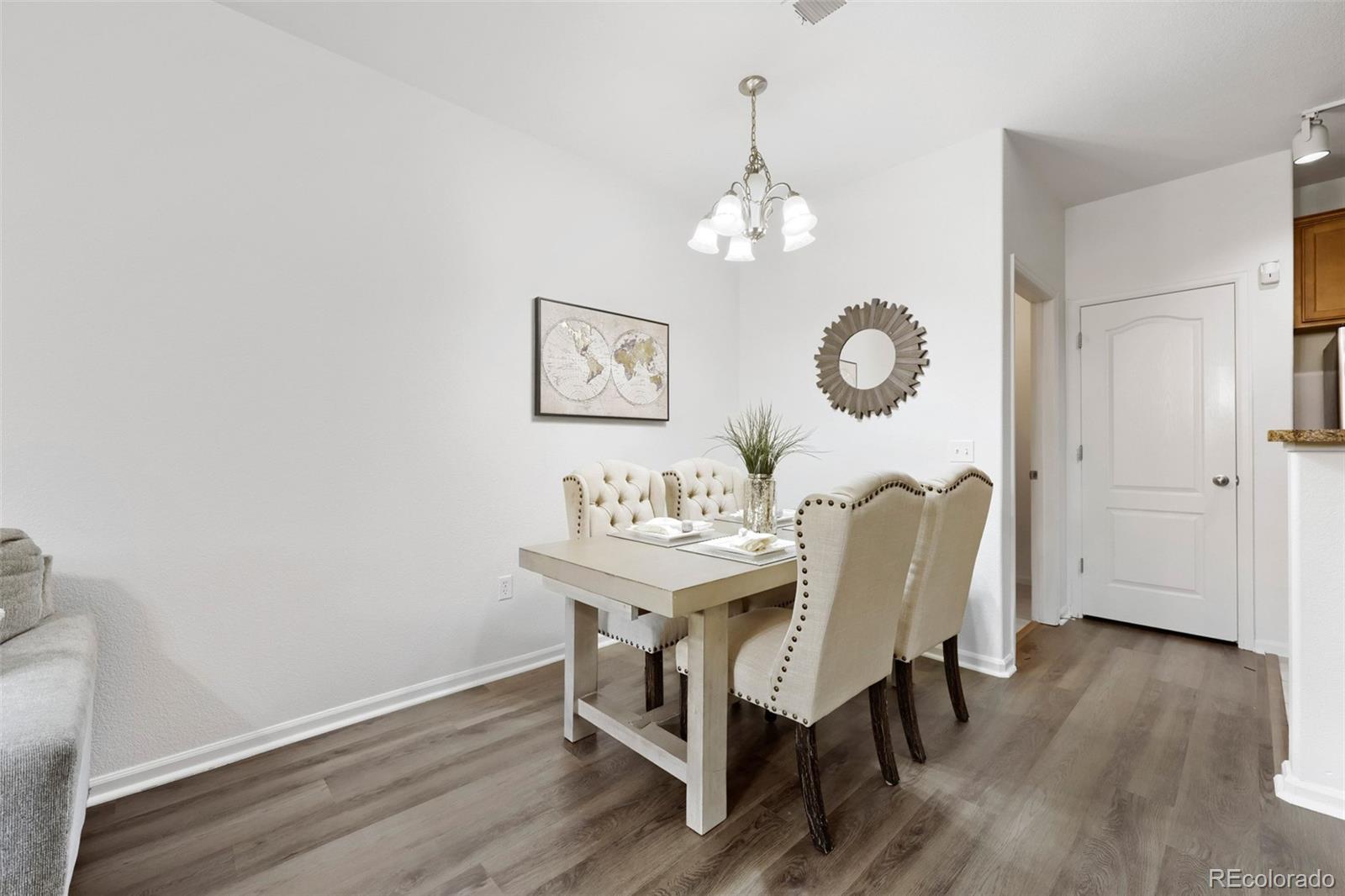 7130 Simms Street, Unit 107 Arvada, CO 80004 - Photo 8 of 29 a view of a dining room with furniture wooden floor and a chandelier