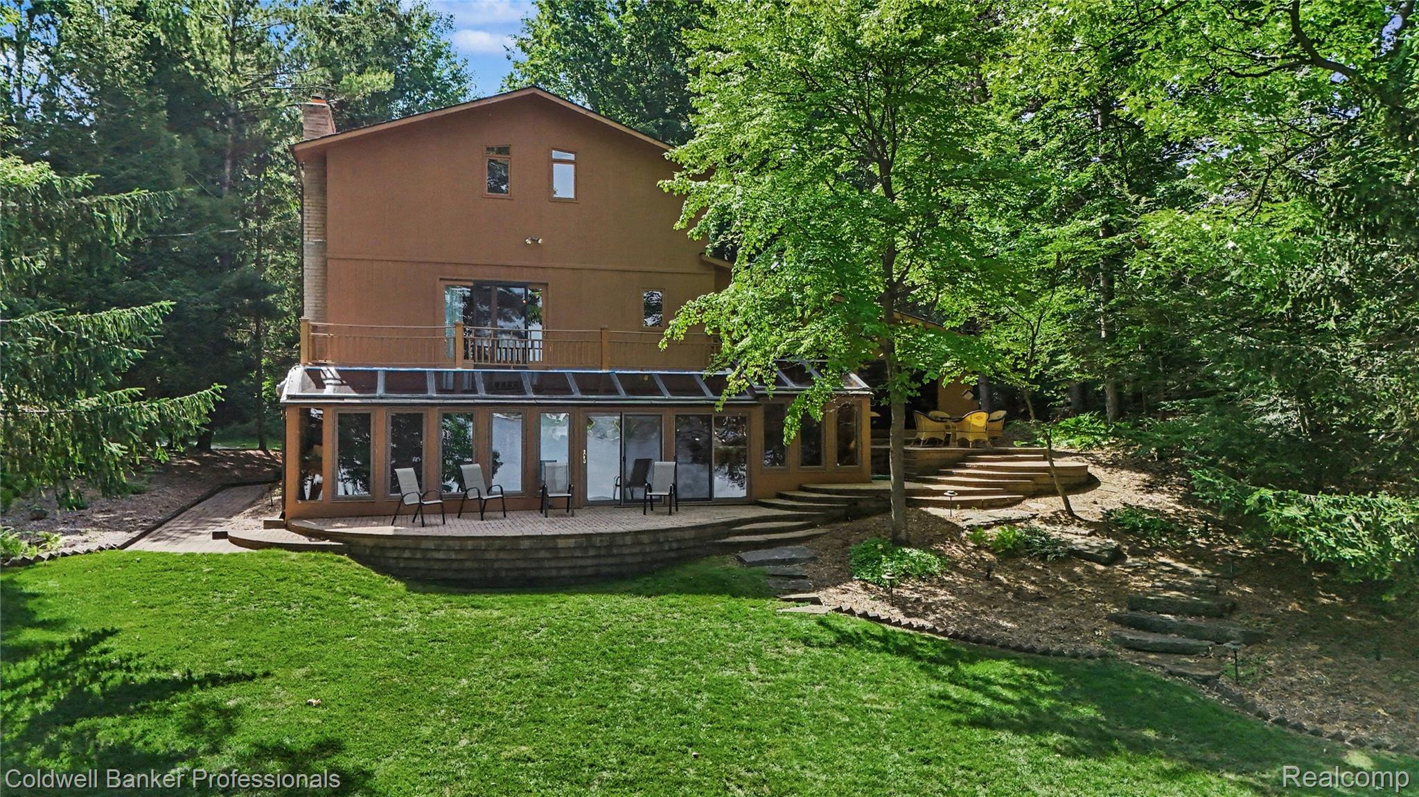 3583 Mitchell Road Metamora, MI 48455 - Photo 12 of 58 Terraced backyard featuring a spacious patio, a sunroom with extensive glazing, and multiple access points to the main residence