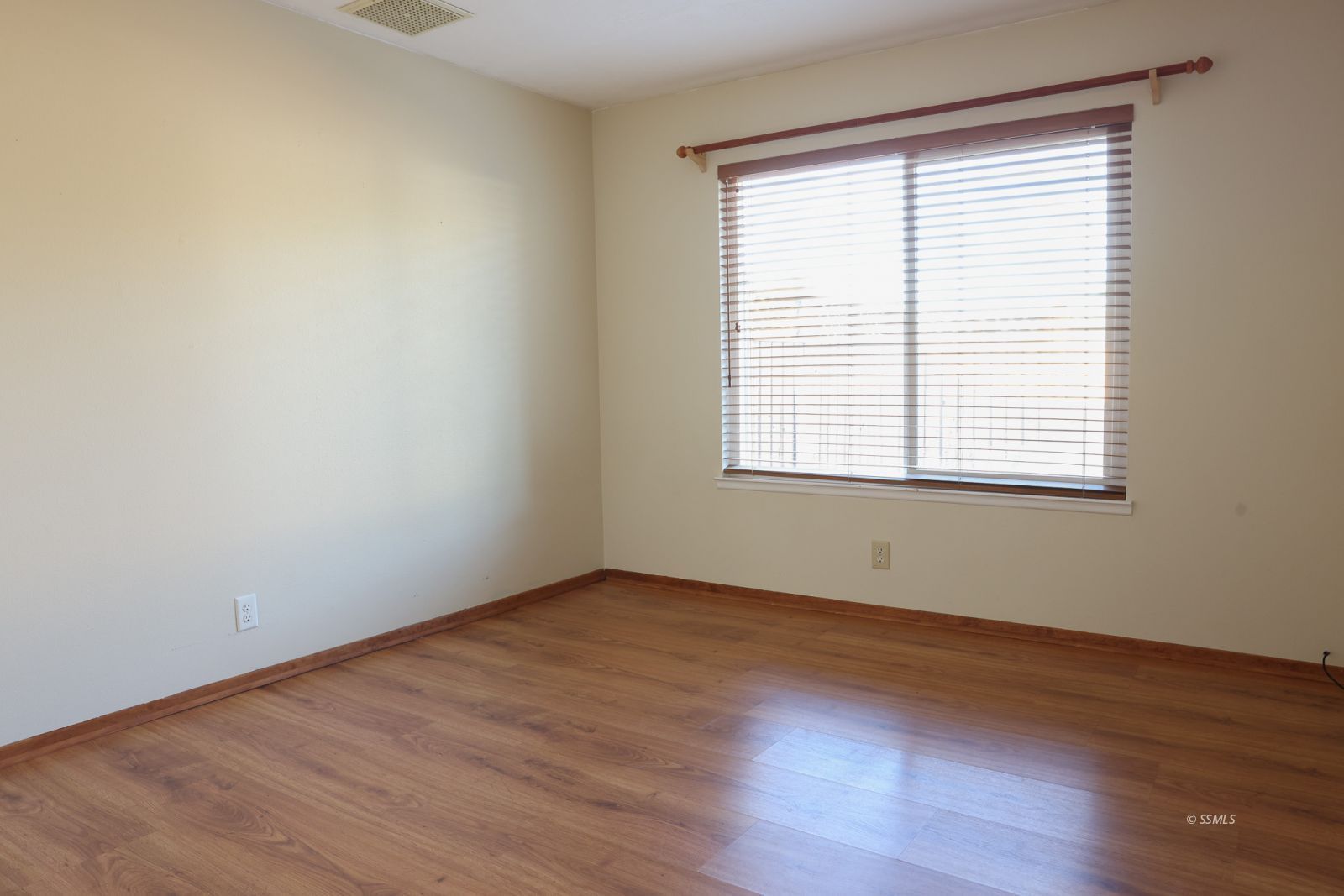 1051 Peg Street Ridgecrest, CA 93555 - Photo 21 of 34 a view of an empty room with wooden floor and a window