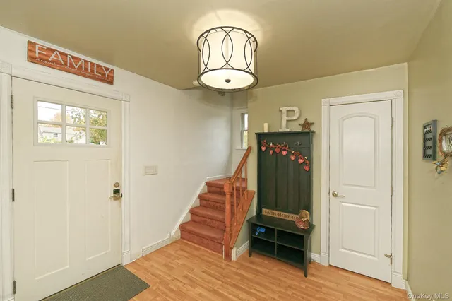 a view of a hallway with wooden floor and entryway