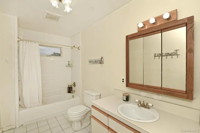 a bathroom with a sink a toilet and shower a mirror