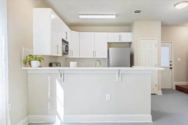 a kitchen with stainless steel appliances a stove microwave and a refrigerator