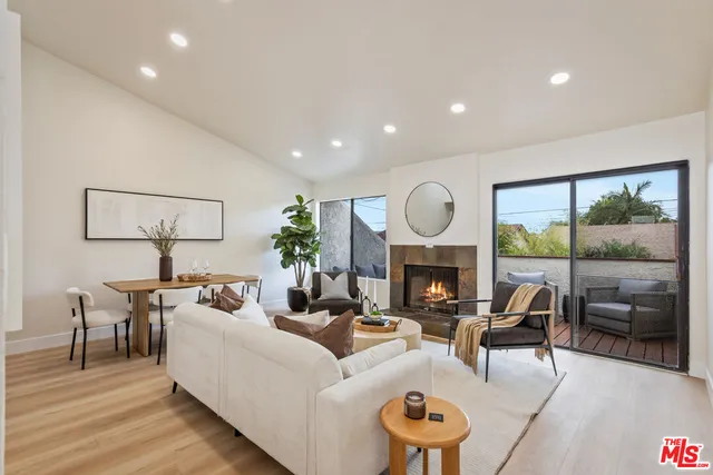 a living room with furniture a fireplace and a floor to ceiling window