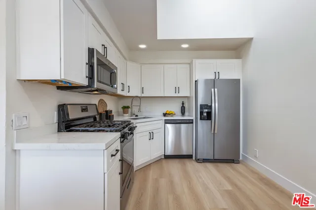 a kitchen with stainless steel appliances granite countertop a refrigerator stove a sink and a microwave