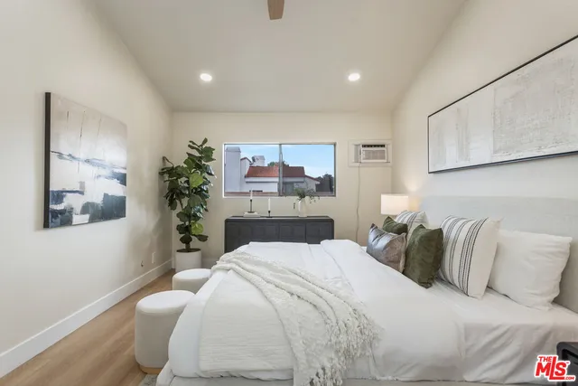a bedroom with a large bed and a potted plant