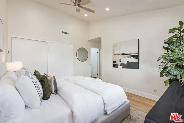 a bedroom with a bed and a potted plant