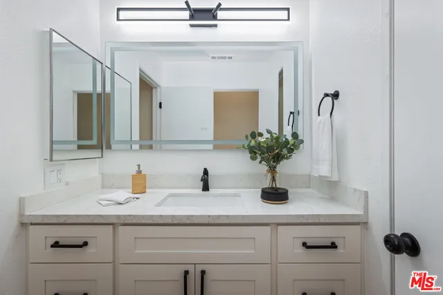 a bathroom with a sink a vanity and a mirror
