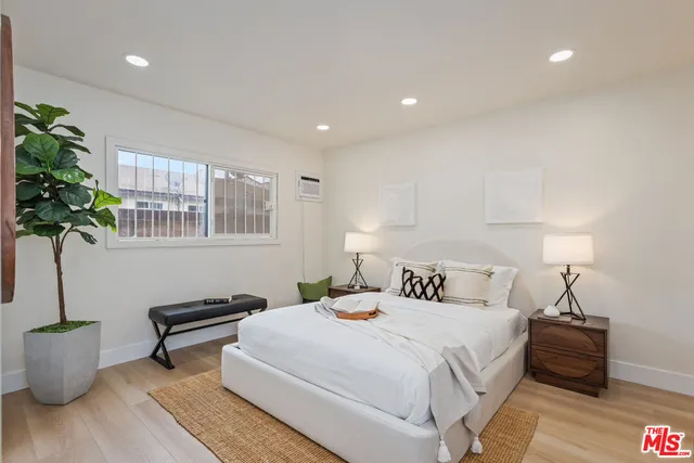 a bedroom with a bed and a potted plant
