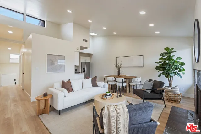 a living room with furniture kitchen view and a potted plant