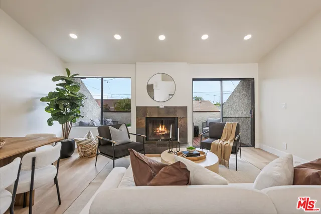 a living room with furniture a fireplace and a potted plant