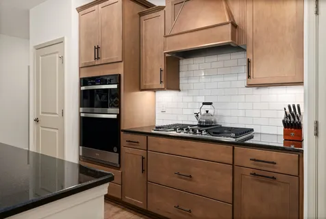 a kitchen with stainless steel appliances granite countertop a refrigerator stove and sink