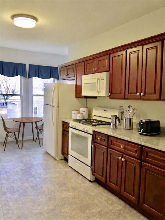 218 Whitman Avenue, Unit 2 Whitman, MA 02382 - Photo 4 of 15 a kitchen with stainless steel appliances granite countertop a refrigerator sink and cabinets