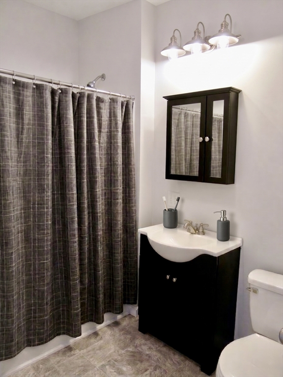 218 Whitman Avenue, Unit 2 Whitman, MA 02382 - Photo 10 of 15 a bathroom with a toilet a sink and mirror