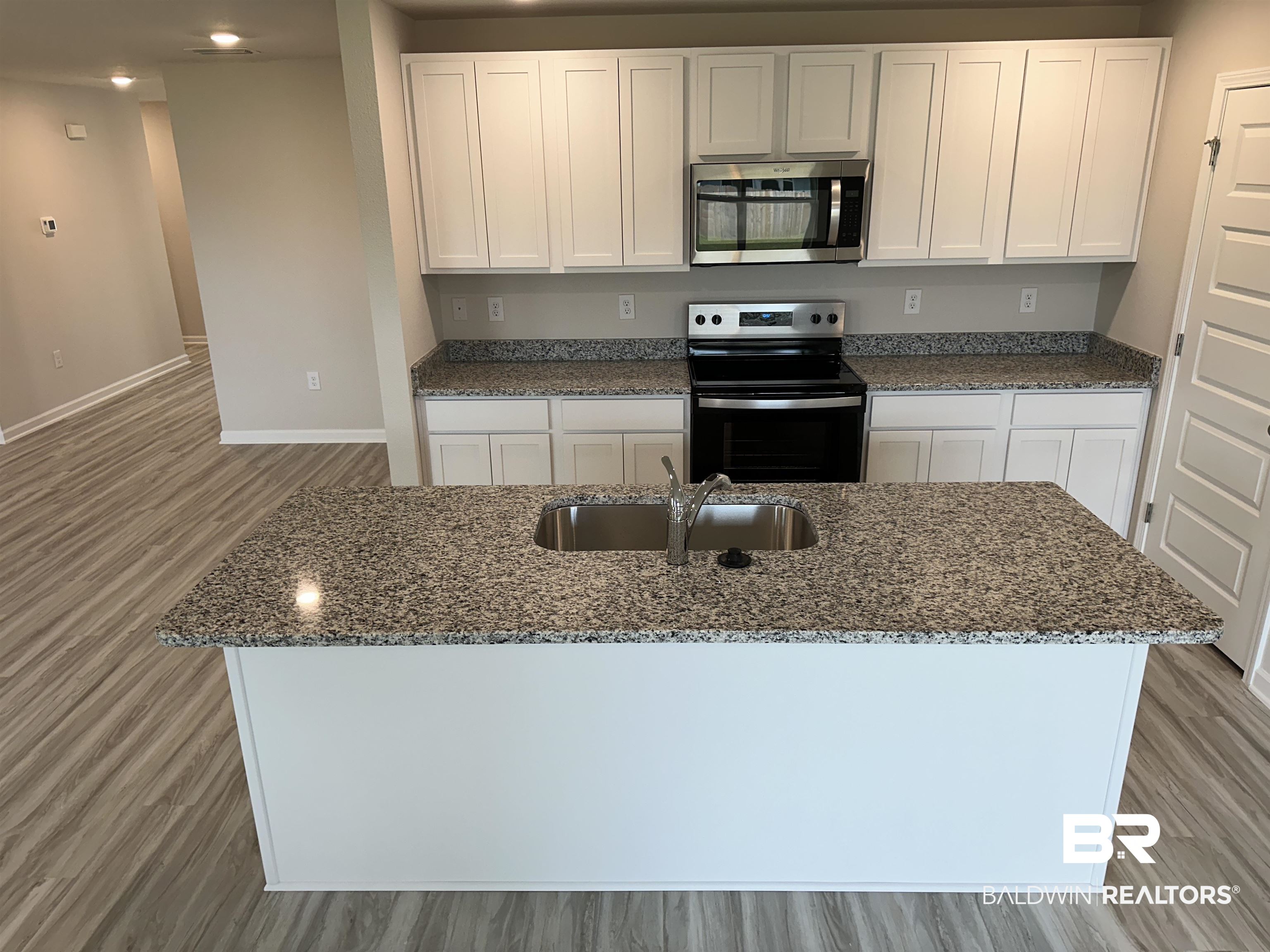 8850 Sea Star Circle Foley, AL 36535 - Photo 28 of 29 Kitchen featuring stainless steel appliances, white cabinets, sink, an island with sink, and light hardwood / wood-style flooring