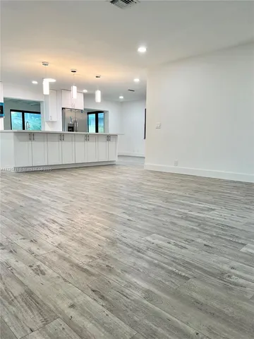 a view of a kitchen with a sink and wooden floor