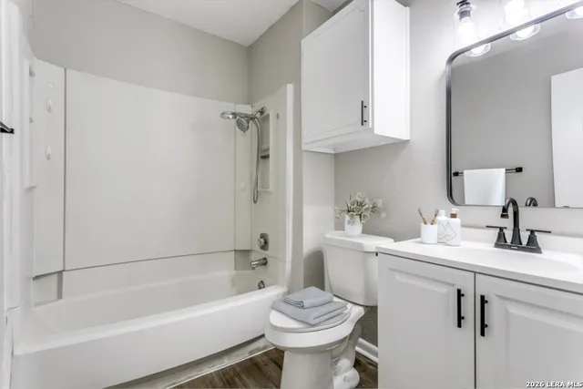 a bathroom with a sink toilet vanity and tub