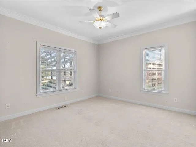 an empty room with a window and a ceiling fan