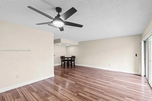 a view of dining room with wooden floor and a ceiling fan