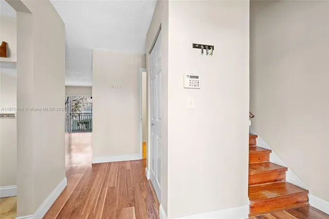 a view of a hallway with wooden floor and staircase
