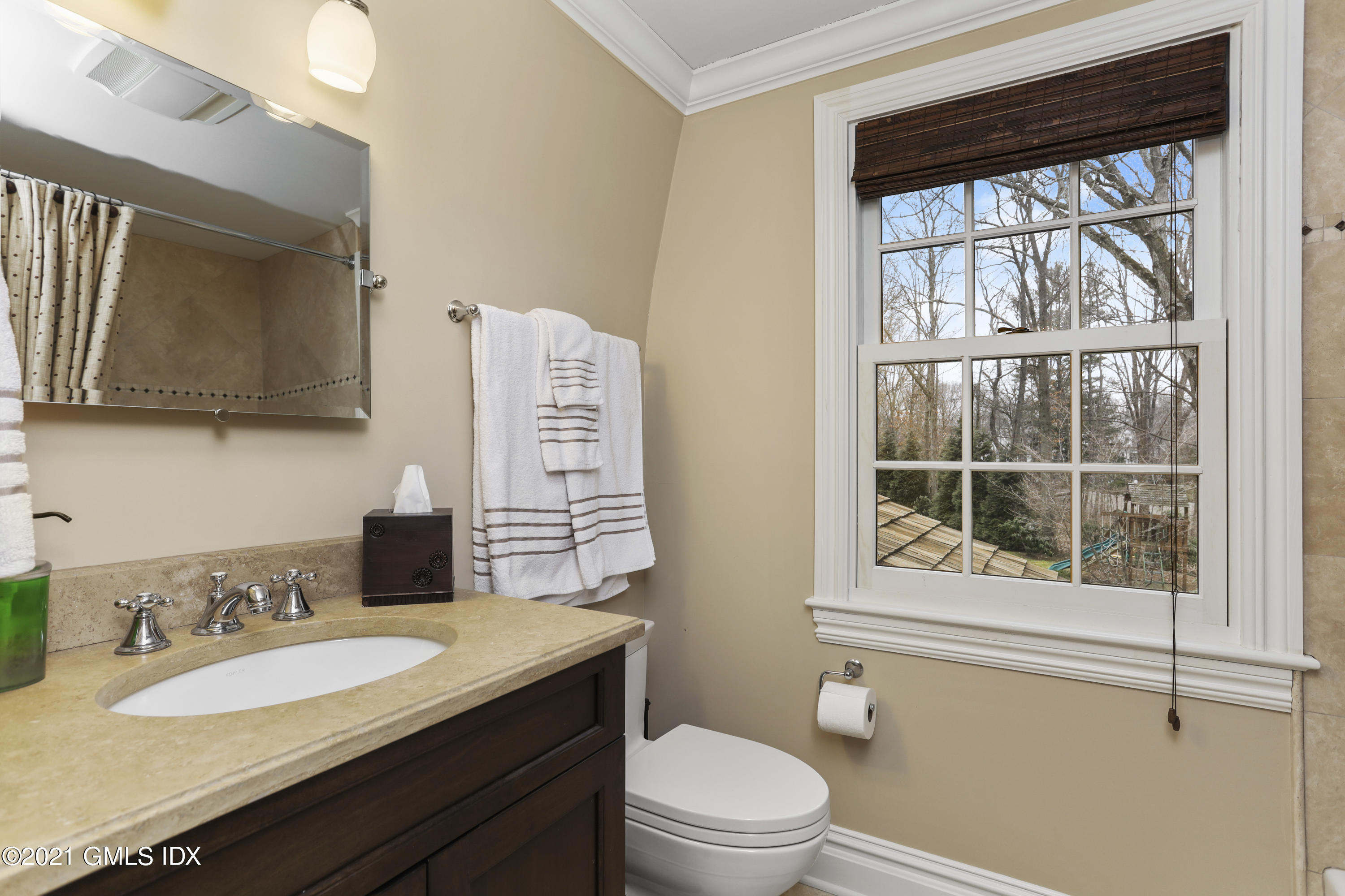 265 Riversville Road Greenwich, CT 06831 - Photo 35 of 47 a bathroom with a granite countertop sink toilet a mirror and next to a window