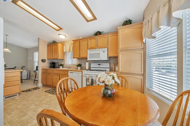 a kitchen with stainless steel appliances granite countertop a dining table and chairs