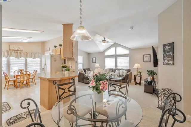 a view of a dining room and livingroom with furniture wooden floor a chandelier
