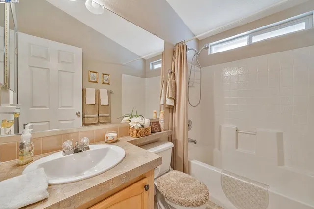 a bathroom with a granite countertop sink mirror toilet and bathtub