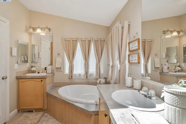 a bathroom with a tub sink and mirror