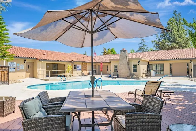 a view of a patio with a dining table and chairs under an umbrella