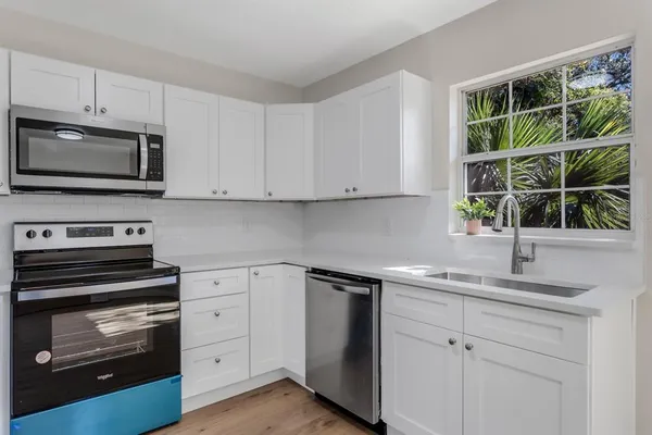 a kitchen with a sink stove and microwave