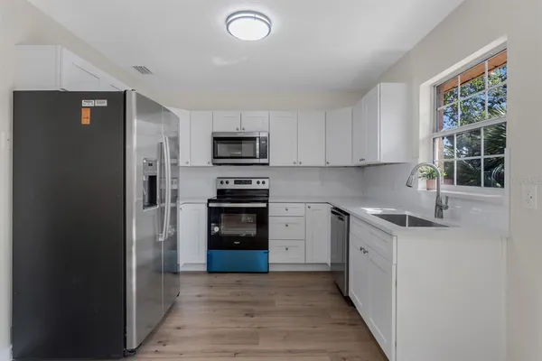 a kitchen with kitchen island granite countertop a stove cabinets and refrigerator