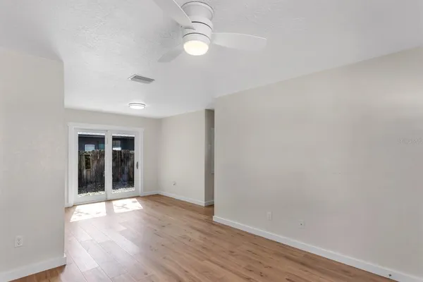 an empty room with wooden floor and windows