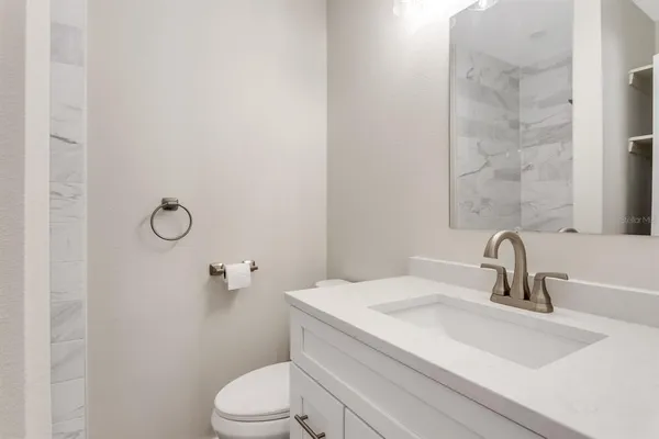 a bathroom with a sink toilet and mirror
