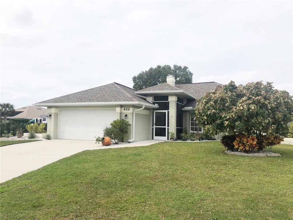 a front view of a house with a yard and potted plants