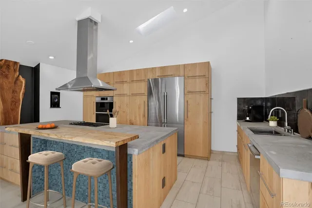 a kitchen with stainless steel appliances kitchen island sink refrigerator and stove