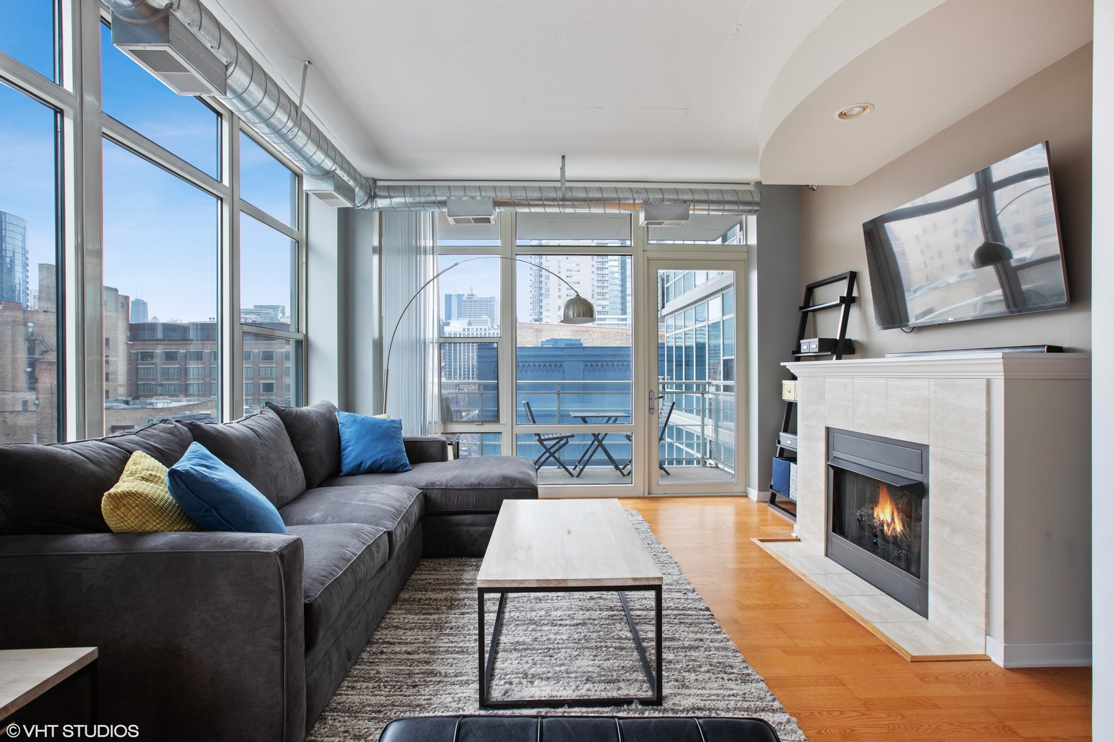 909 West Washington Boulevard, Unit 513 Chicago, IL 60607 - Photo 2 of 16 a living room with furniture large windows and a fireplace