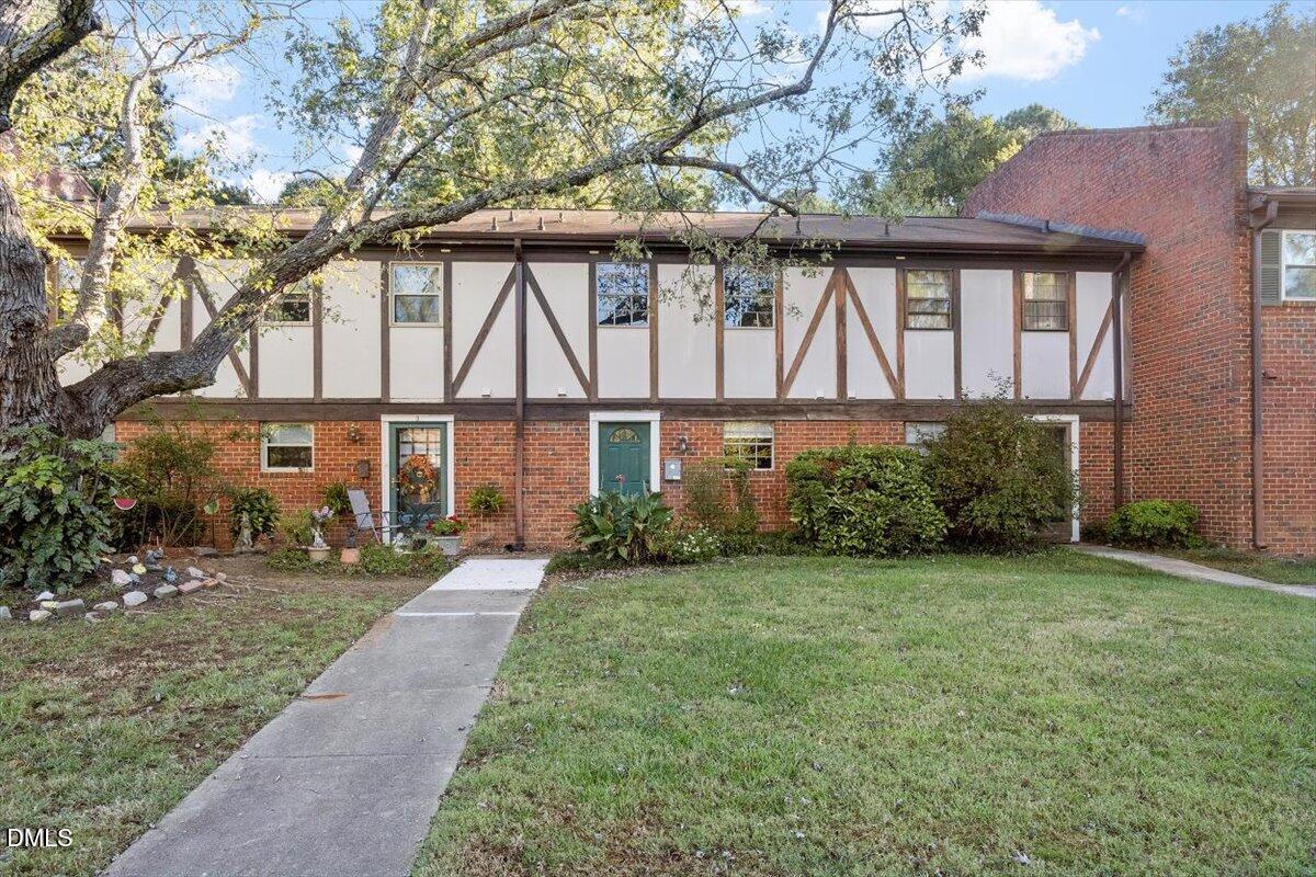 a front view of a house with a yard and trees