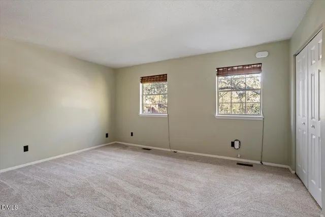 a bedroom with a bed potted plant on the dresser and floor