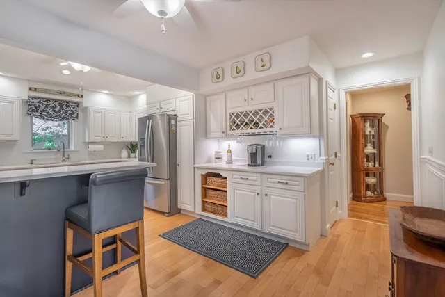 a kitchen with stainless steel appliances a sink cabinets and wooden floor