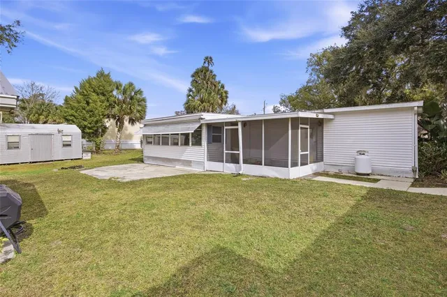 a front view of house with yard and trees in the background
