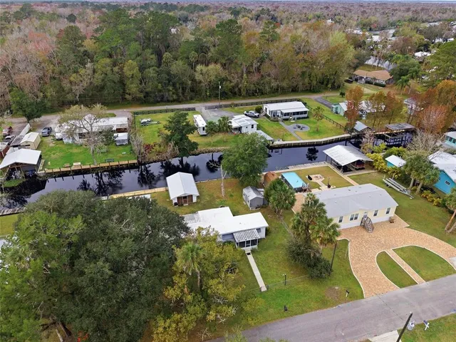 an aerial view of a house with a swimming pool outdoor seating and yard