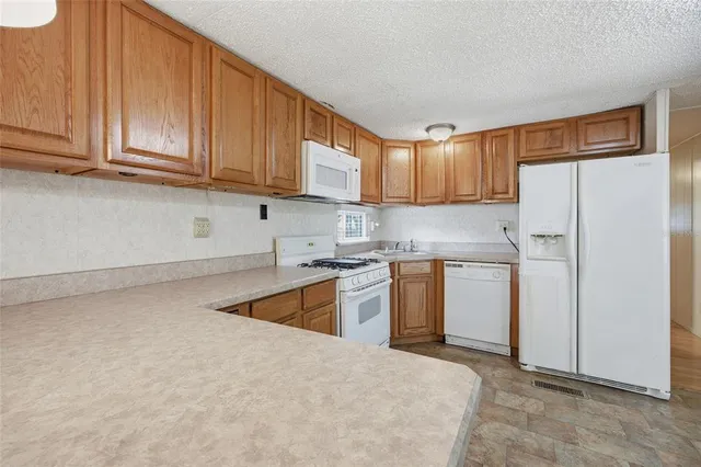 a kitchen with stainless steel appliances granite countertop a refrigerator sink and cabinets