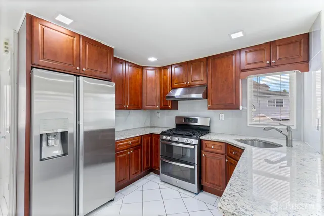 a kitchen with stainless steel appliances granite countertop a refrigerator stove and cabinets