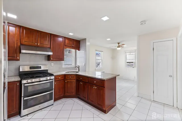 a kitchen with stainless steel appliances granite countertop a stove a sink and a refrigerator