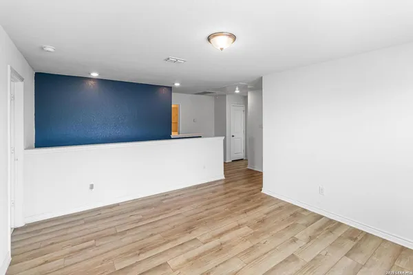 a view of an empty room with wooden floor