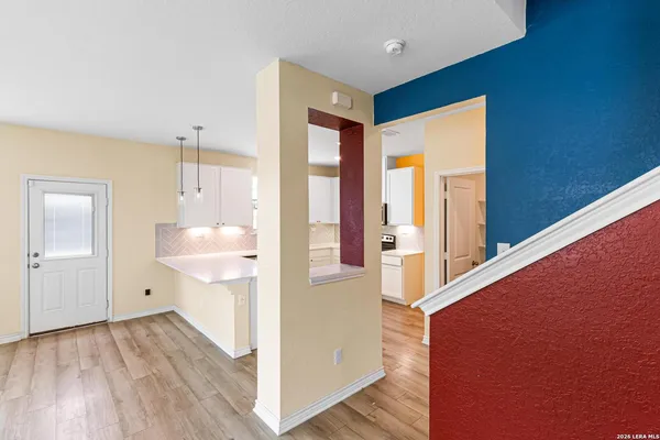a view of a hallway with wooden floor and entryway