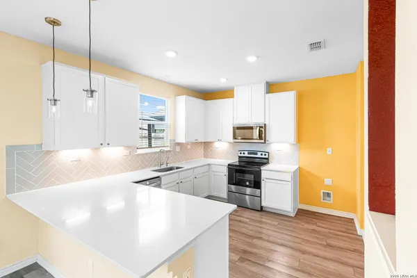 a kitchen with stainless steel appliances granite countertop a sink a stove and a refrigerator