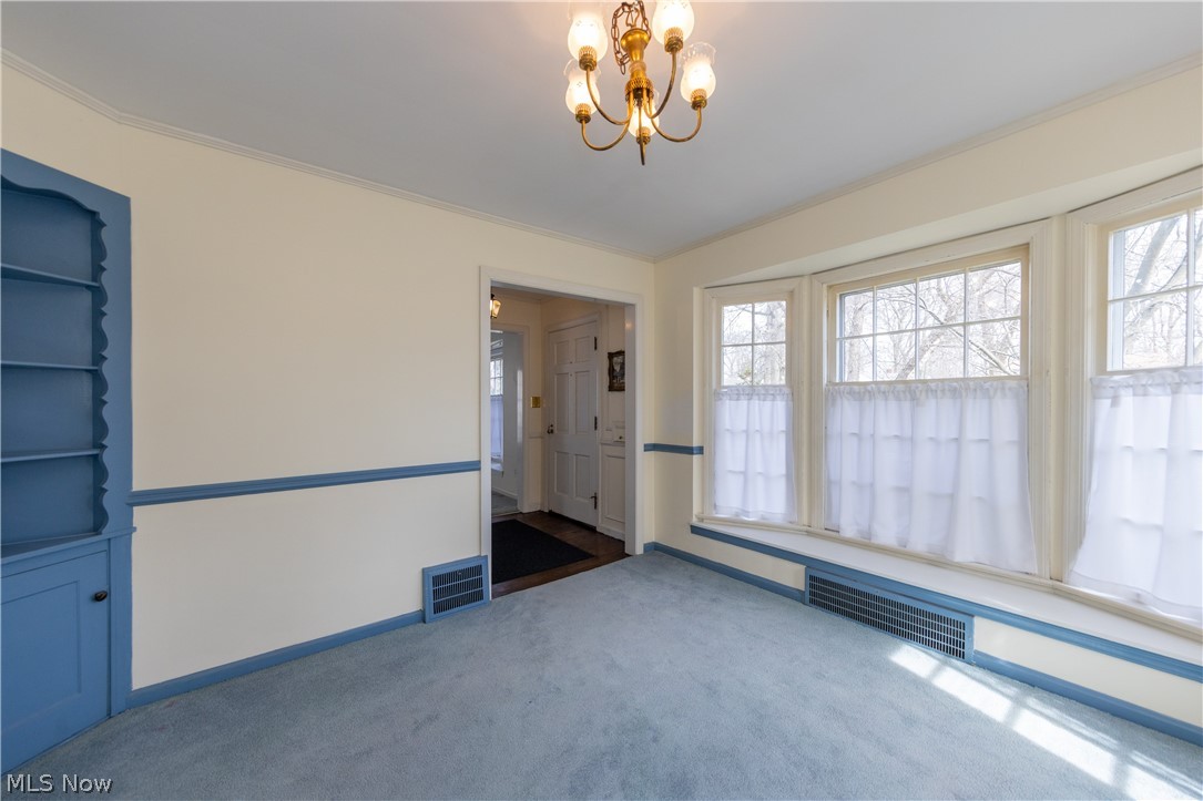 1050 Renfield Road Cleveland Heights, OH 44121 - Photo 12 of 41 Dining room with an inviting chandelier, colored carpet, and ornamental molding