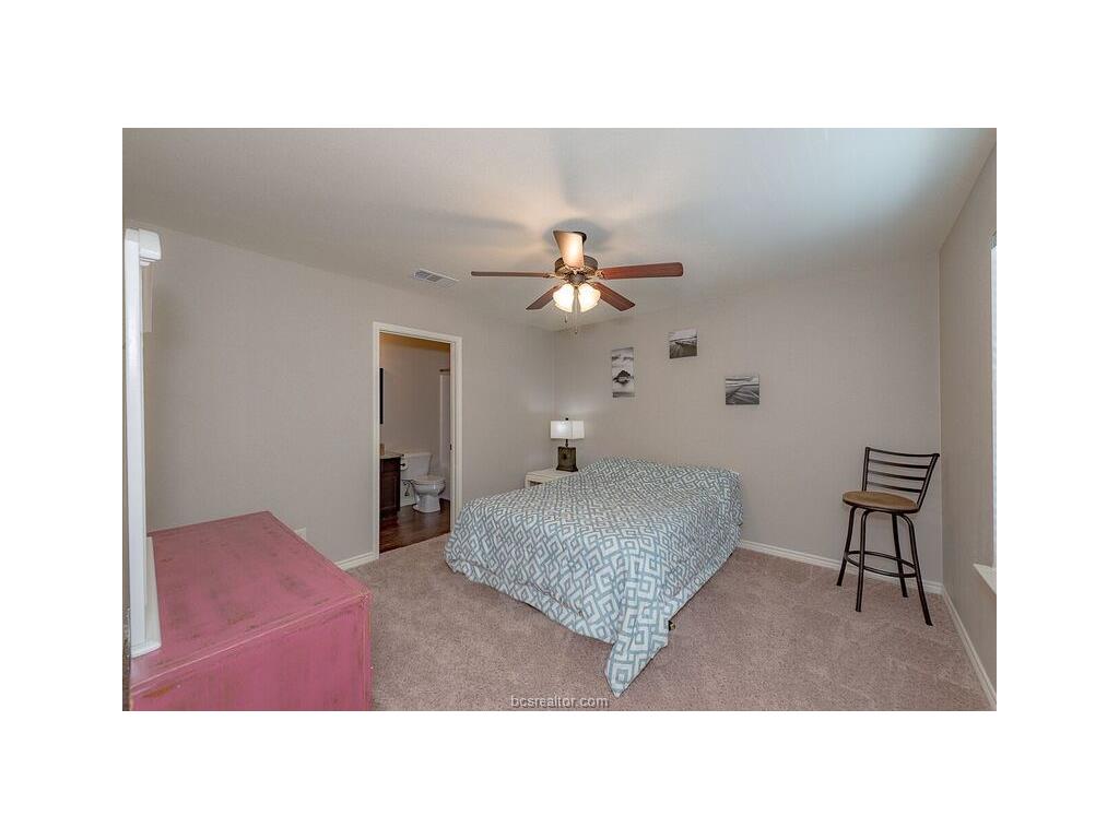 131 Watson Lane Bryan, TX 77801 - Photo 15 of 20 Bedroom with ceiling fan, light colored carpet, and ensuite bath